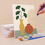 Painting a Quiet Vessels mini canvas propped up beside numbered acrylic paints
