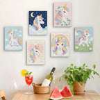 Six finished Rainbow Unicorns mini paintings hung on a wall above a table