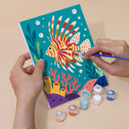 Hand holding a Reef Friends mini canvas while painting the details