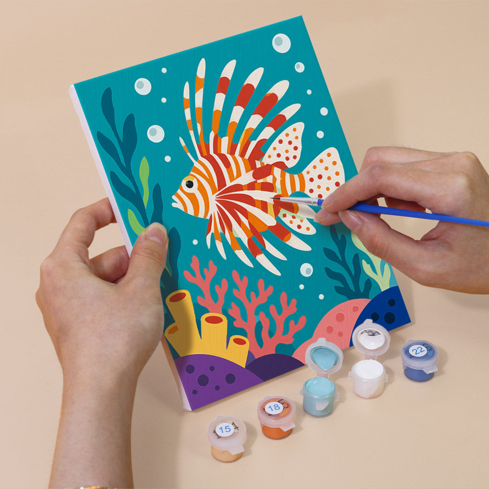 Hand holding a Reef Friends mini canvas while painting the details