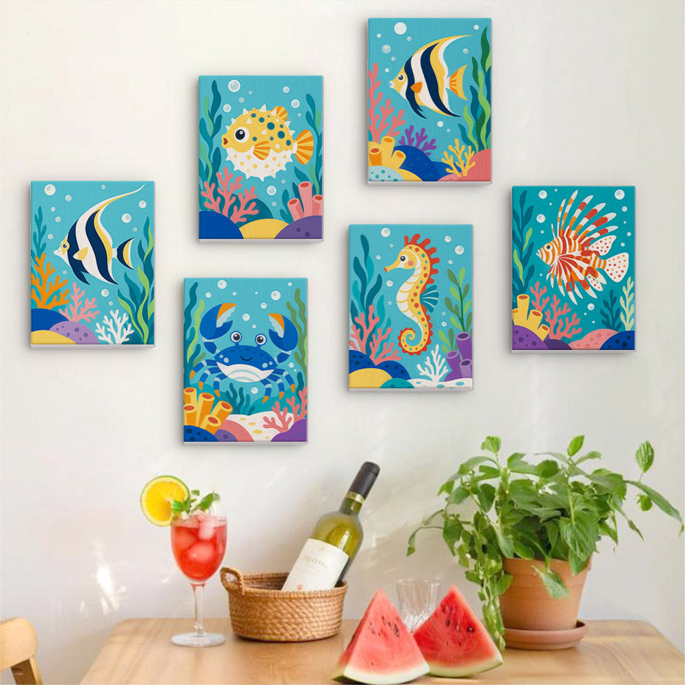 Six finished Reef Friends mini paintings hung on a wall above a table