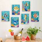 Six finished Reef Friends mini paintings hung on a wall above a table