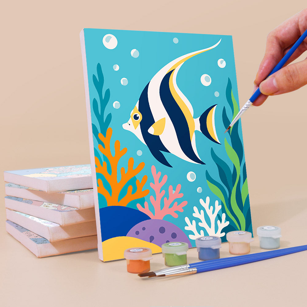 Painting a Reef Friends mini canvas propped up beside numbered acrylic paints