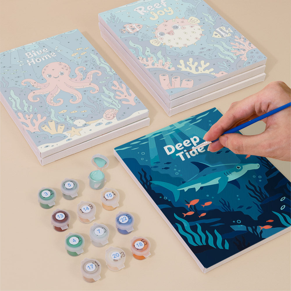 Painting one of the Reef Joy designs next to a stack of mini canvases