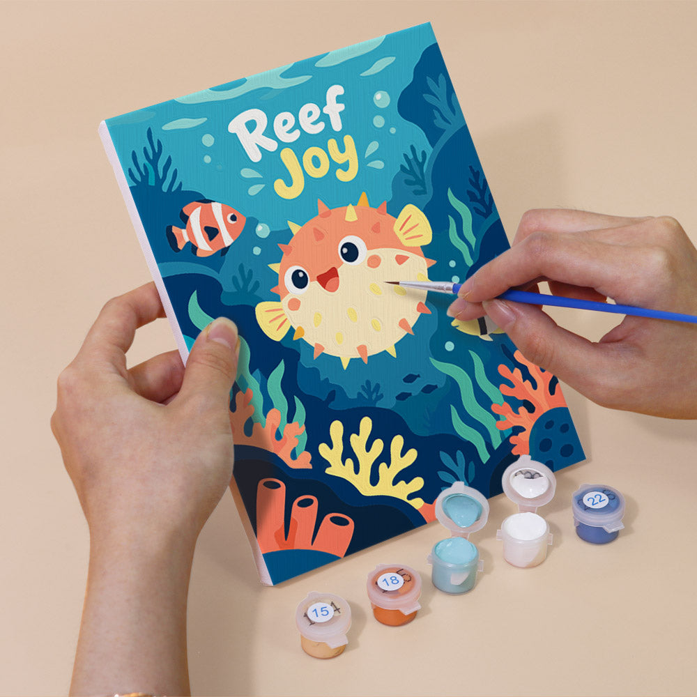 Hand holding a Reef Joy mini canvas while painting the details