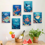 Six finished Reef Joy mini paintings hung on a wall above a table