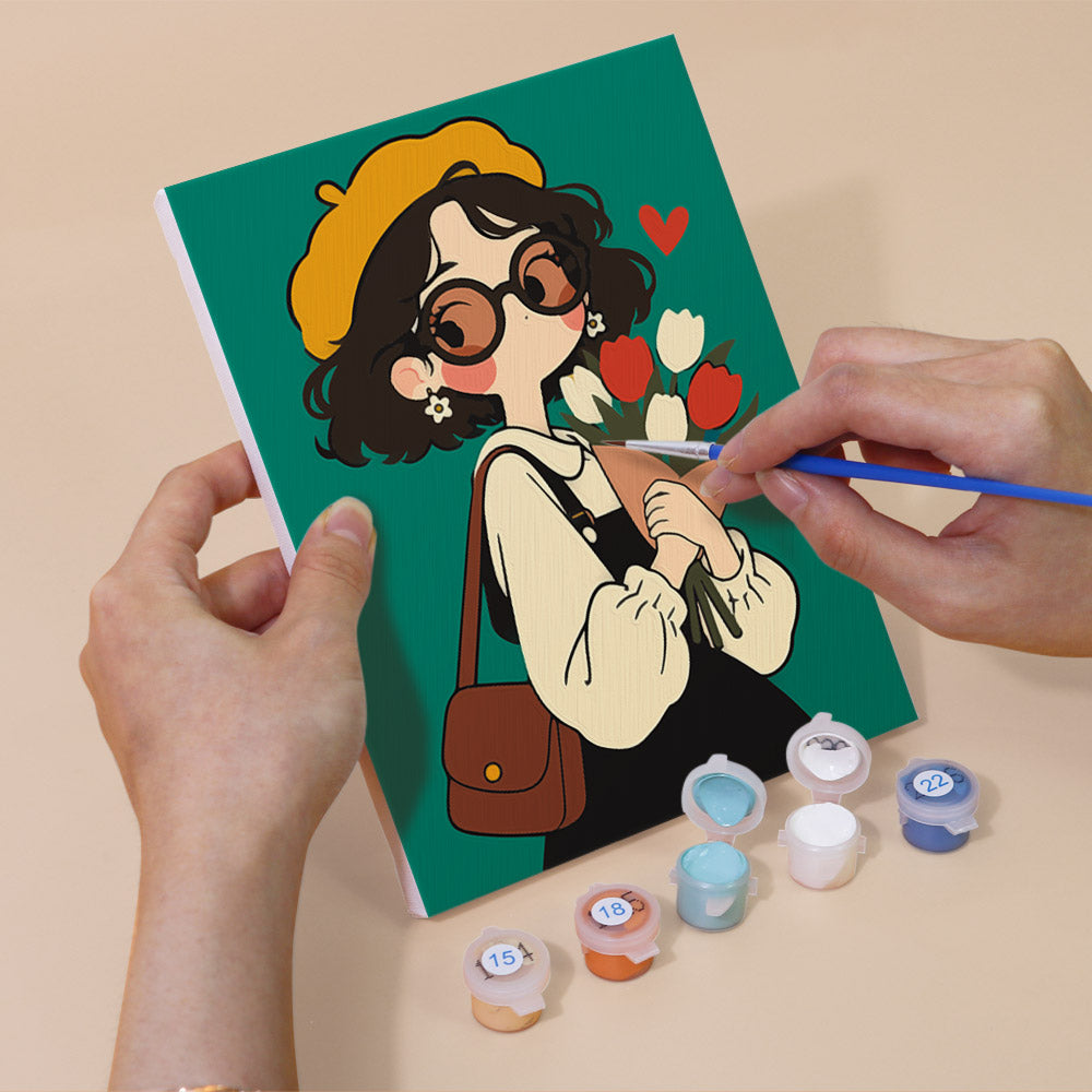 Hand holding a Retro Curls mini canvas while painting the details