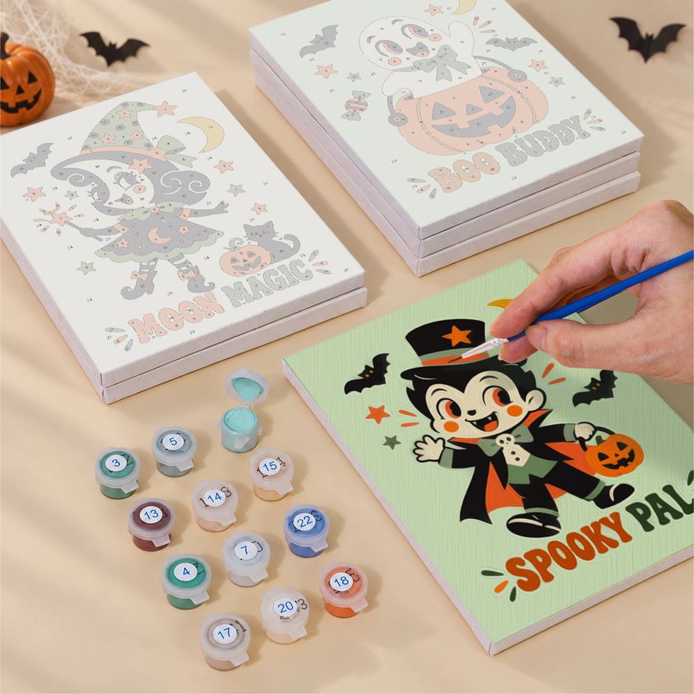 Painting one of the Retro Spooky Pals designs next to a stack of mini canvases