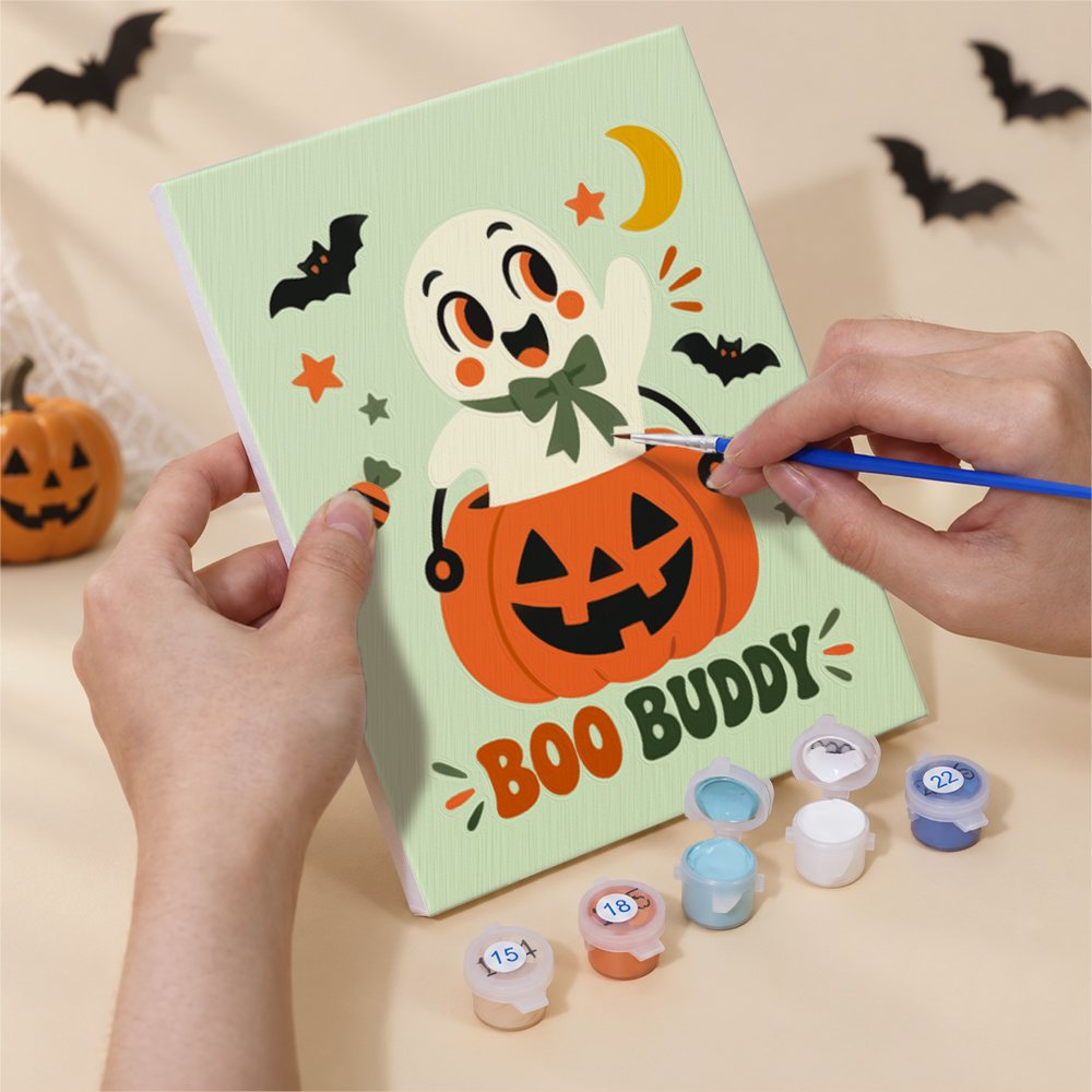 Hand holding a Retro Spooky Pals mini canvas while painting the details