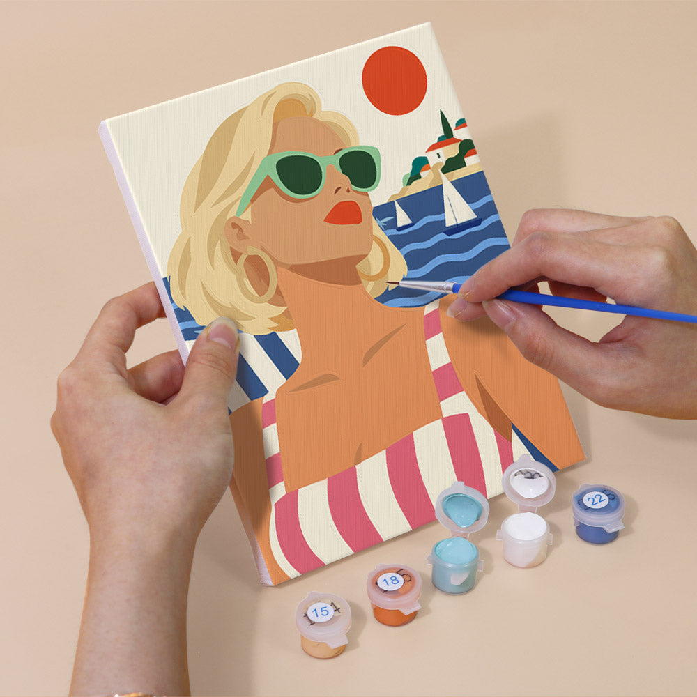 Hand holding a Riviera Chic mini canvas while painting the details