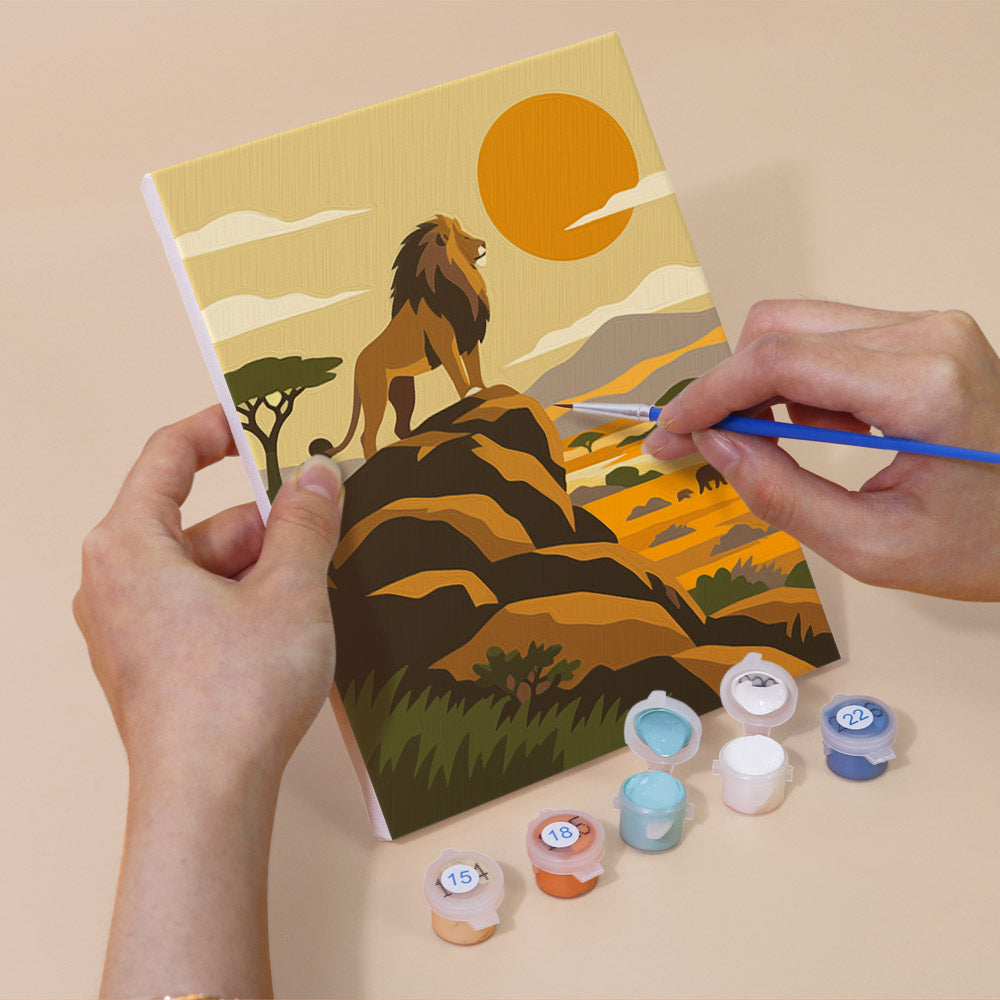 Hand holding a Safari Sunset mini canvas while painting the details