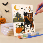 Painting a Salem Black Cat Autumn mini canvas propped up beside numbered acrylic paints