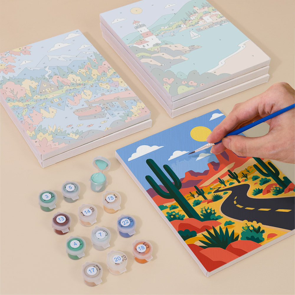 Painting one of the Scenic Escapes designs next to a stack of mini canvases
