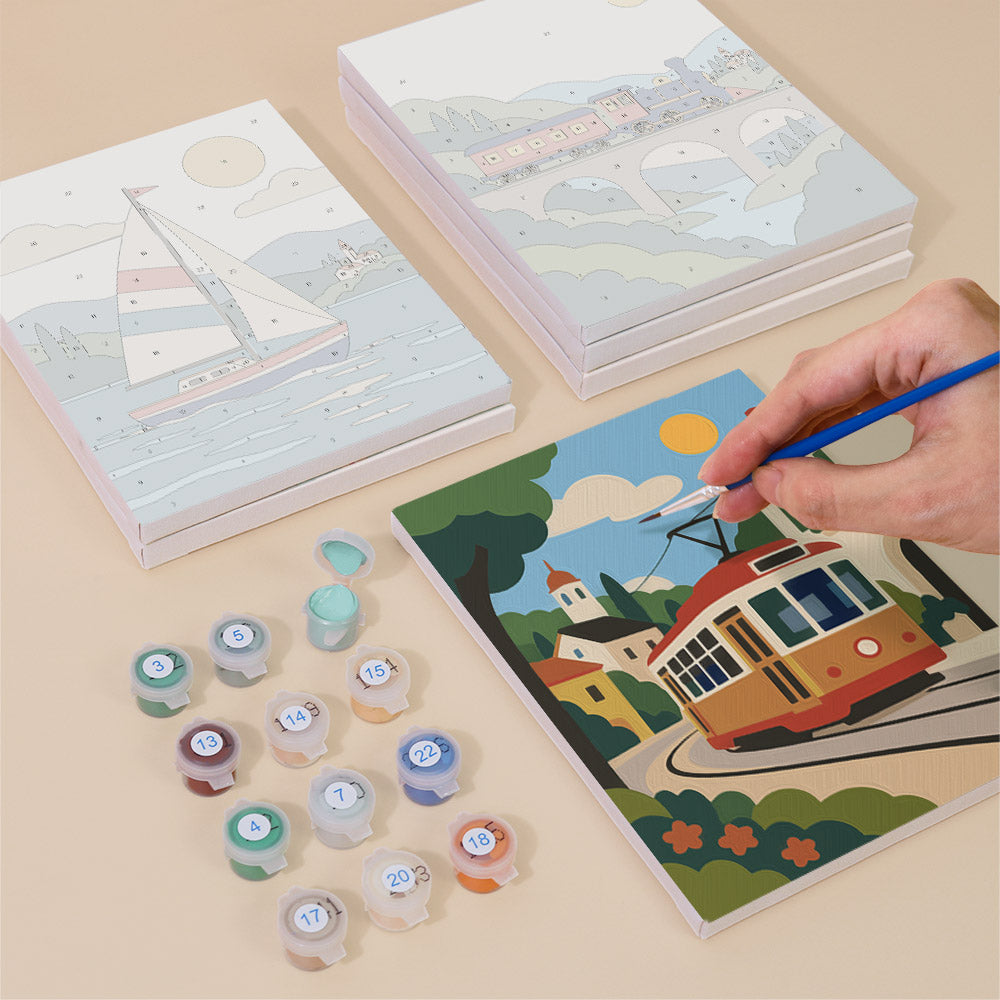 Painting one of the Scenic Rides designs next to a stack of mini canvases