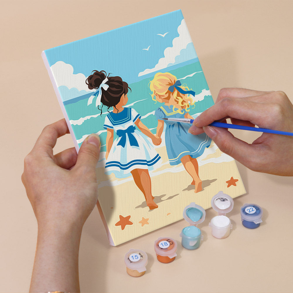 Hand holding a Seaside Friends mini canvas while painting the details