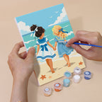 Hand holding a Seaside Friends mini canvas while painting the details