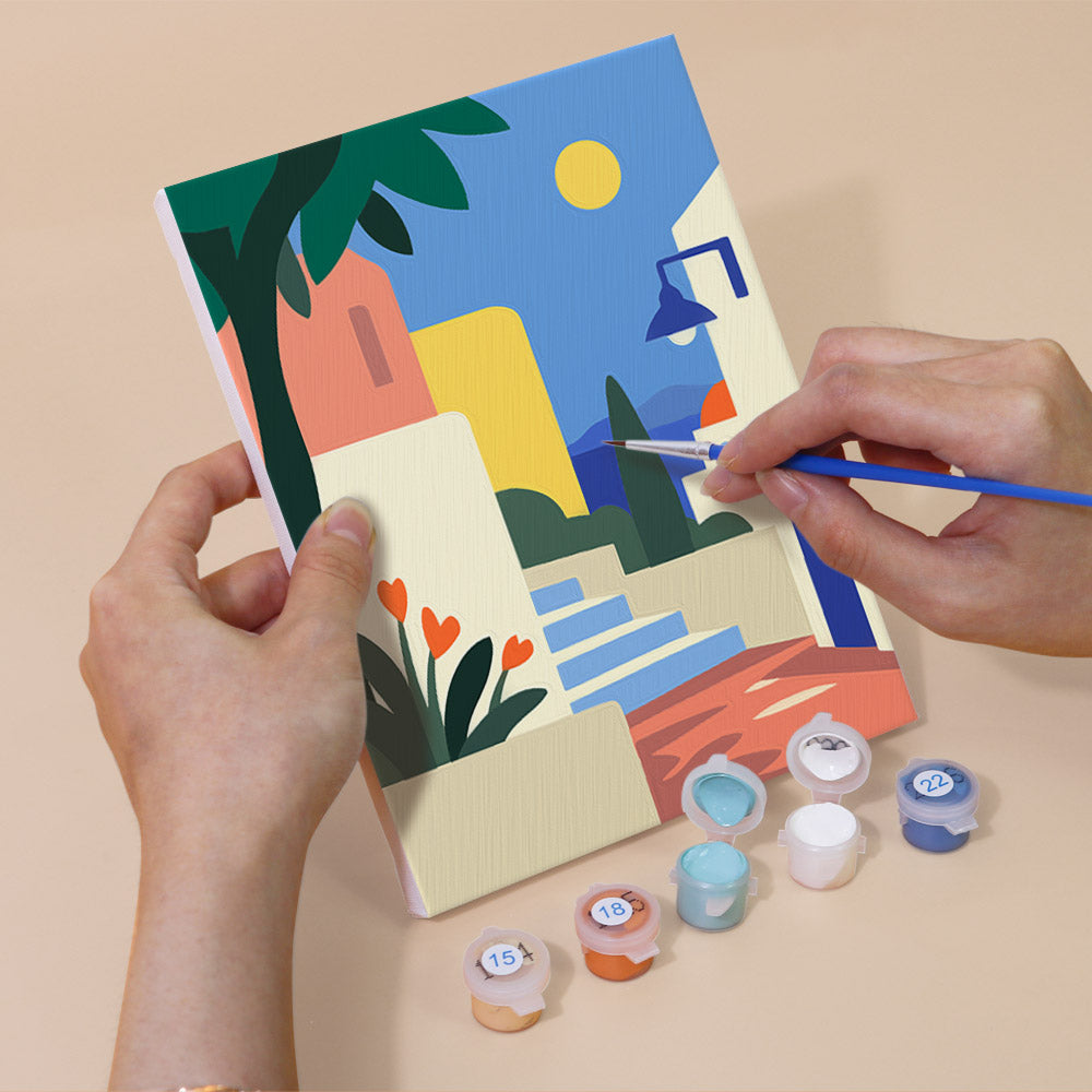 Hand holding a Seaside Terraces mini canvas while painting the details