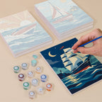 Painting one of the Ships and Sails designs next to a stack of mini canvases