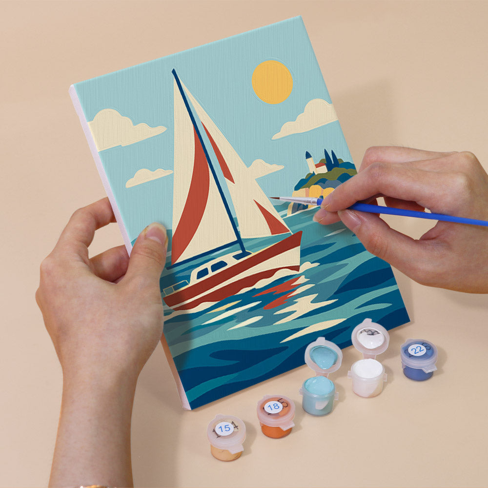 Hand holding a Ships and Sails mini canvas while painting the details