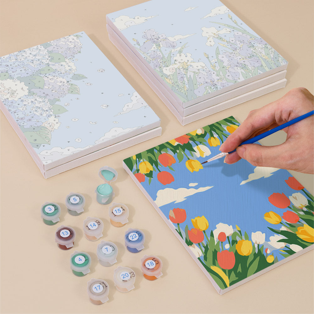 Painting one of the Sky Garden designs next to a stack of mini canvases