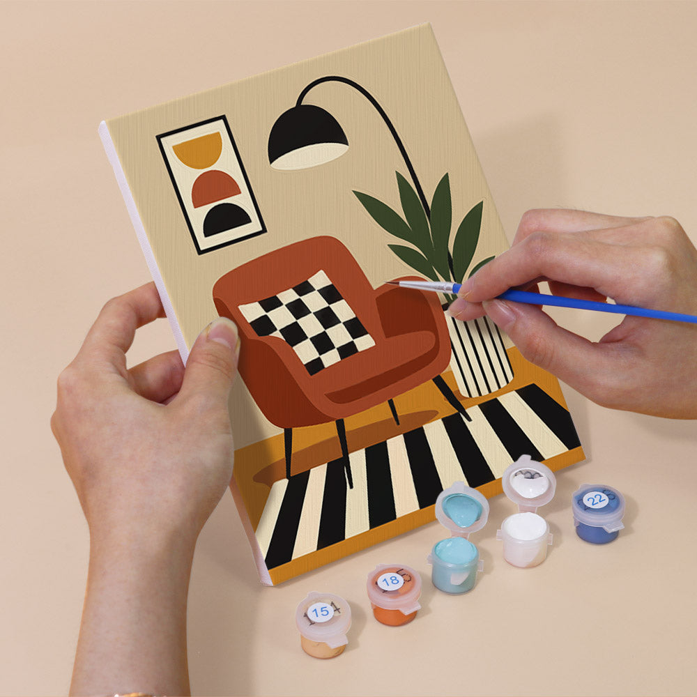 Hand holding a Slow Life mini canvas while painting the details