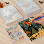Painting one of the Smiling Moon Tales designs next to a stack of mini canvases