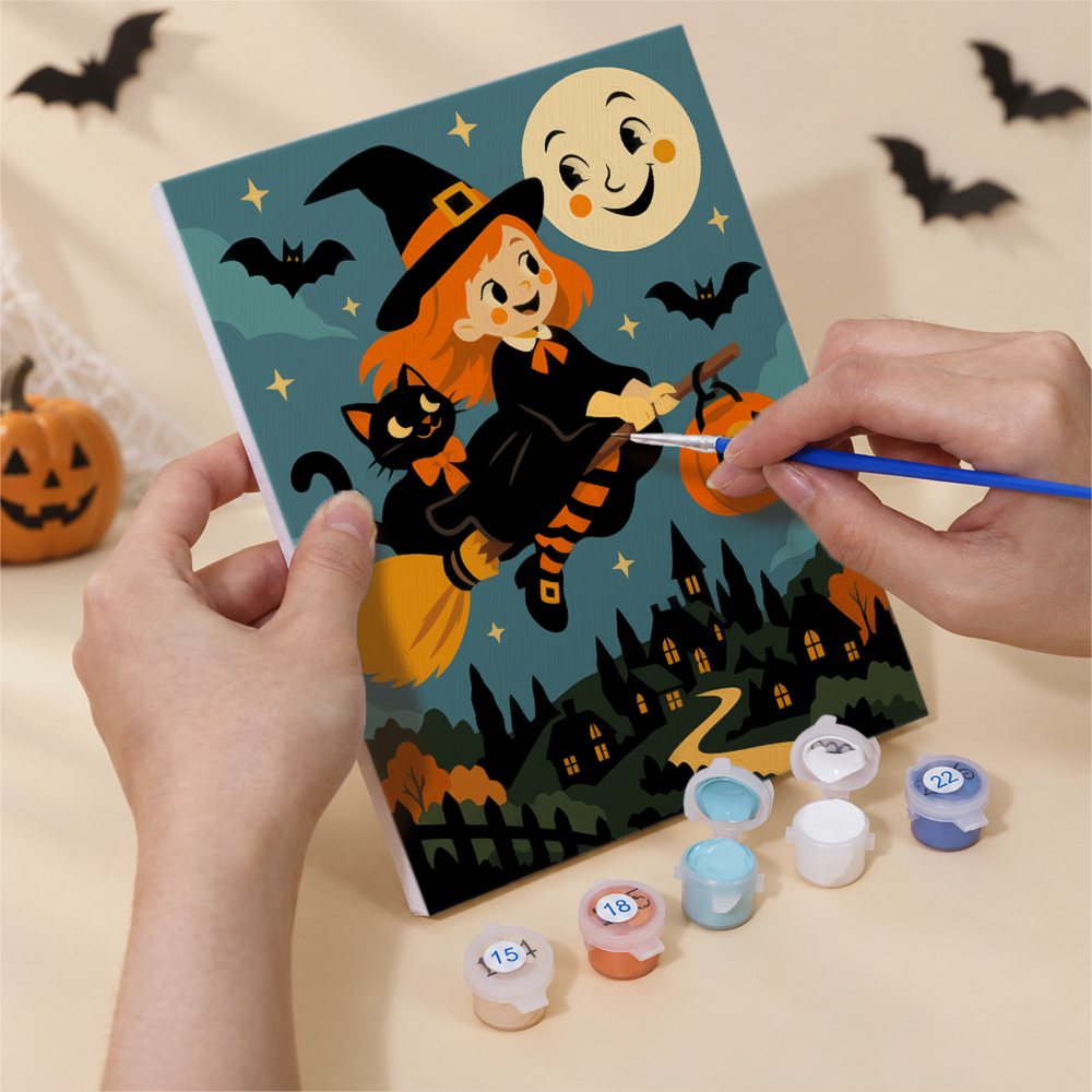 Hand holding a Smiling Moon Tales mini canvas while painting the details