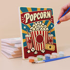Painting a Snack Bar Classics mini canvas propped up beside numbered acrylic paints