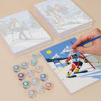 Painting one of the Snow Day Skiers designs next to a stack of mini canvases