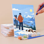 Painting a Snow Day Skiers mini canvas propped up beside numbered acrylic paints