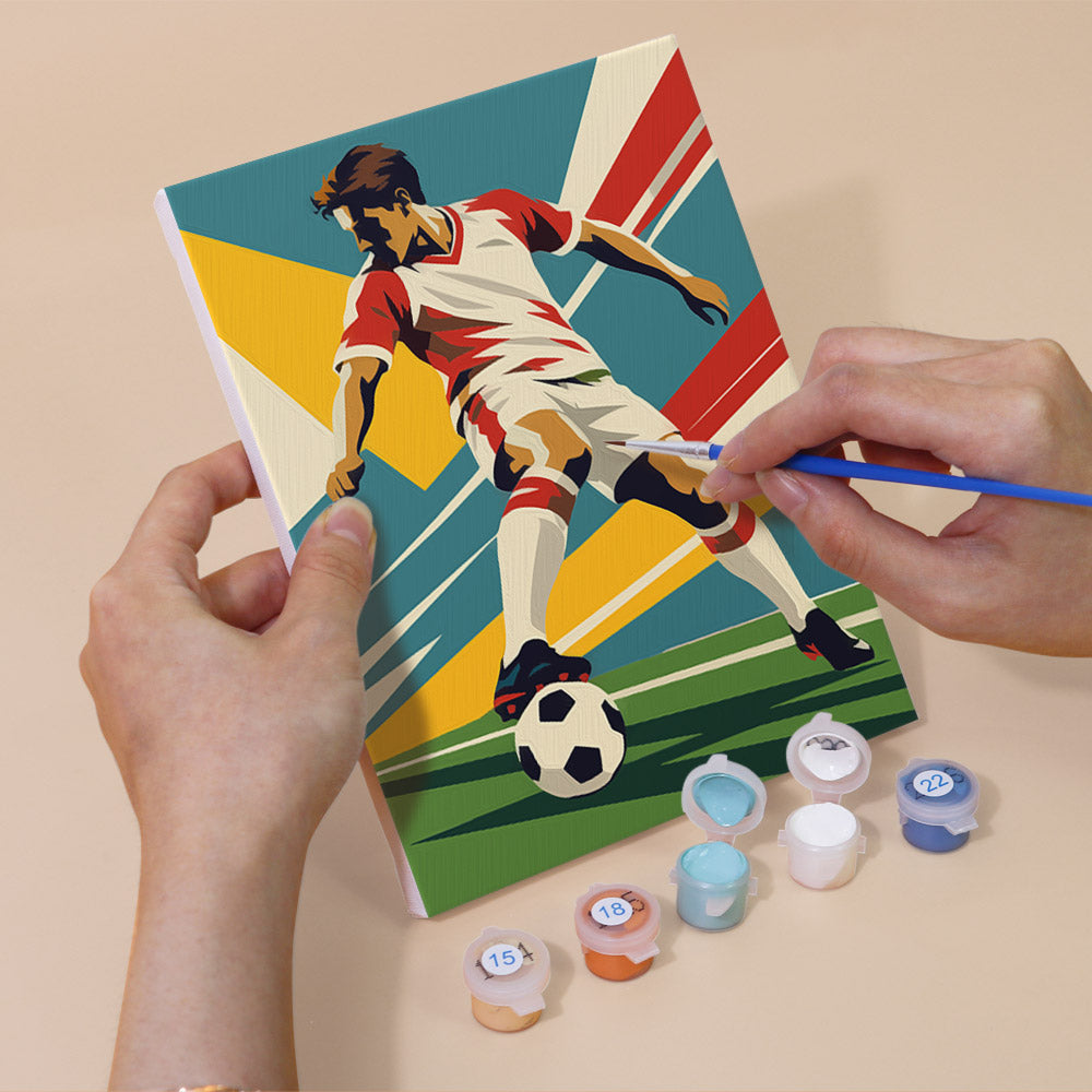 Hand holding a Soccer Glory mini canvas while painting the details
