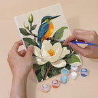 Hand holding a Songbird Blooms mini canvas while painting the details