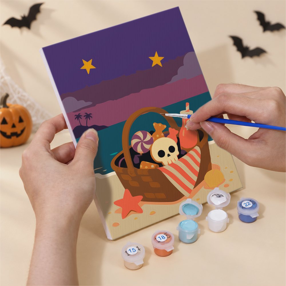 Hand holding a Spooky Beach Party mini canvas while painting the details