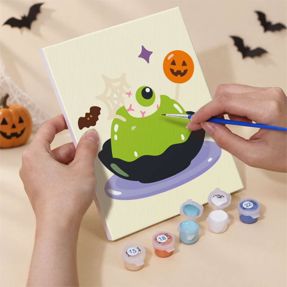 Hand holding a Spooky Dessert Bar mini canvas while painting the details