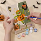 Hand holding a Spooky Frog Masquerade mini canvas while painting the details