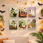 Six finished Spooky Frog Masquerade mini paintings hung on a wall above a table