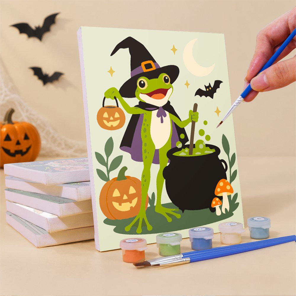 Painting a Spooky Frog Masquerade mini canvas propped up beside numbered acrylic paints