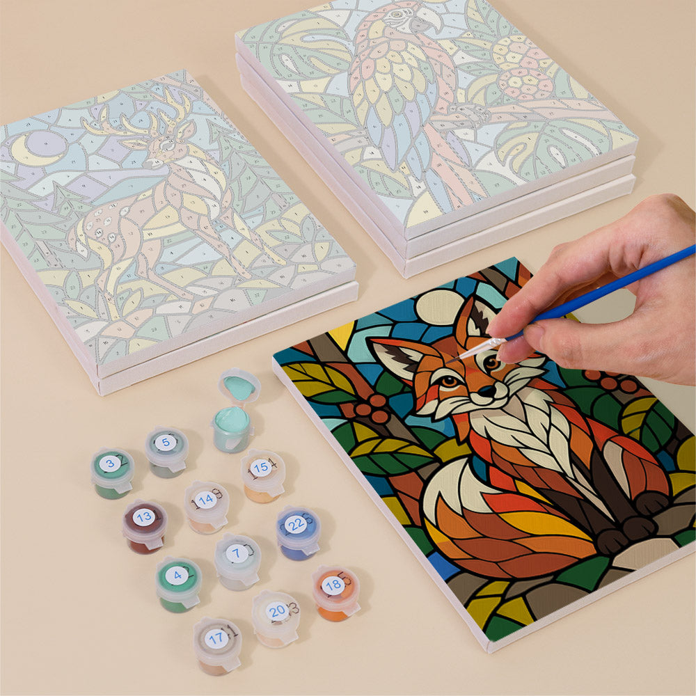 Painting one of the Stained Glass Wildlife designs next to a stack of mini canvases