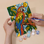 Hand holding a Stained Glass Wildlife mini canvas while painting the details
