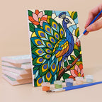Painting a Stained Glass Wildlife mini canvas propped up beside numbered acrylic paints
