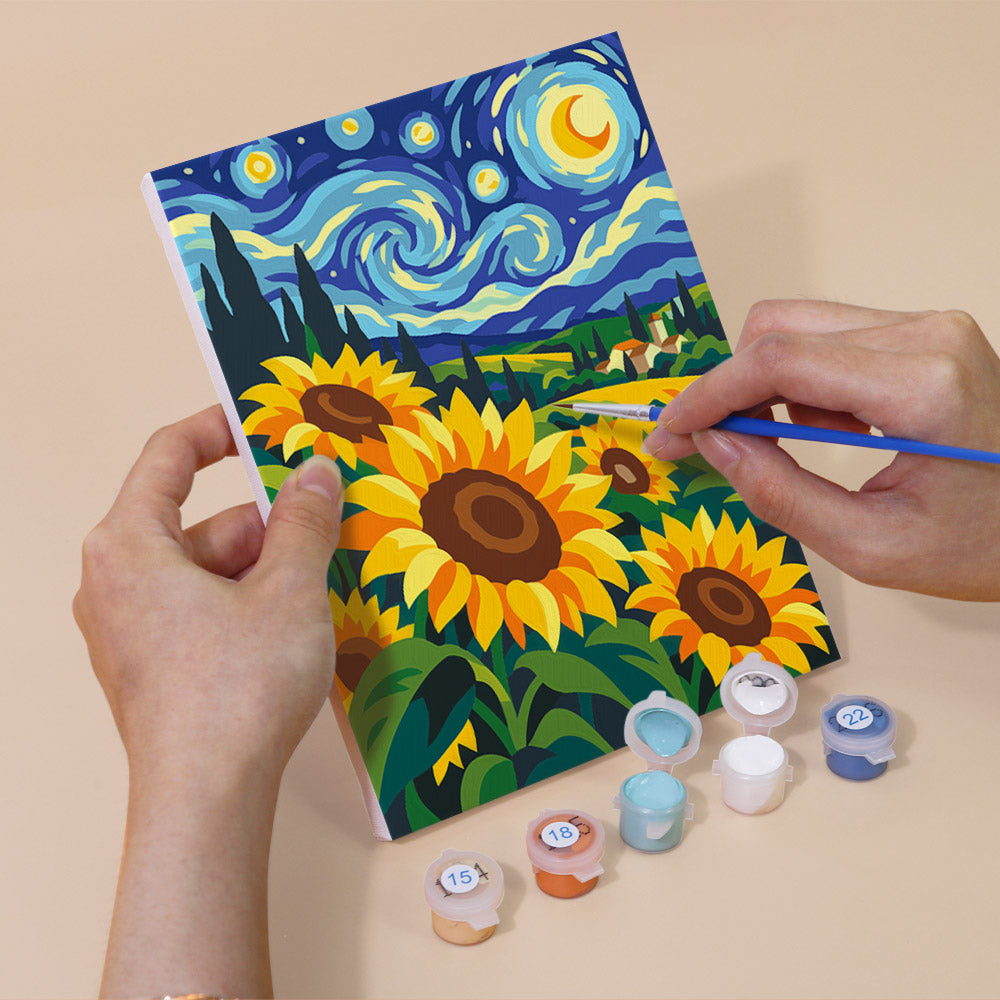 Hand holding a Starry Swirls mini canvas while painting the details