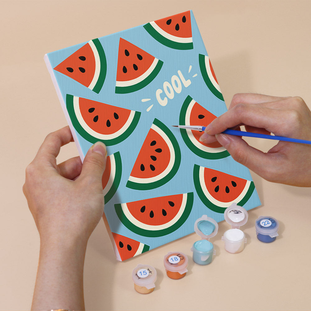 Hand holding a Stay Cool Summer mini canvas while painting the details
