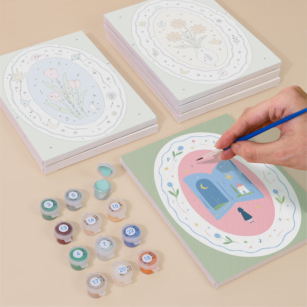 Painting one of the Storybook Cameos designs next to a stack of mini canvases