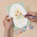 Hand holding a Storybook Cameos mini canvas while painting the details