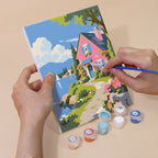 Hand holding a Storybook Villages mini canvas while painting the details