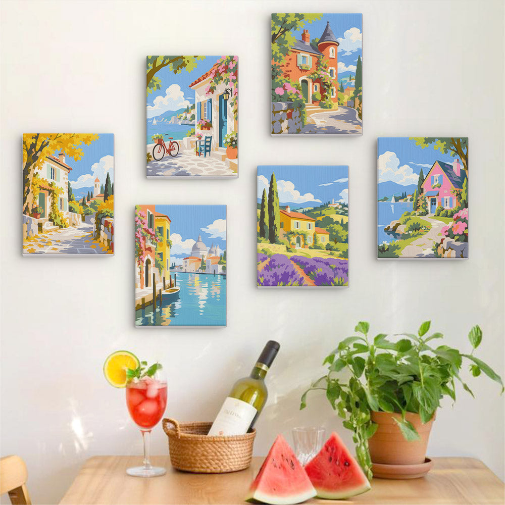 Six finished Storybook Villages mini paintings hung on a wall above a table