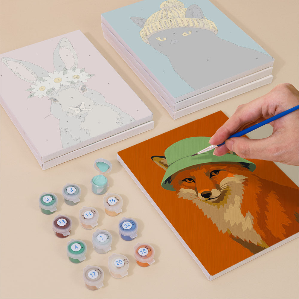 Painting one of the Style Critters designs next to a stack of mini canvases