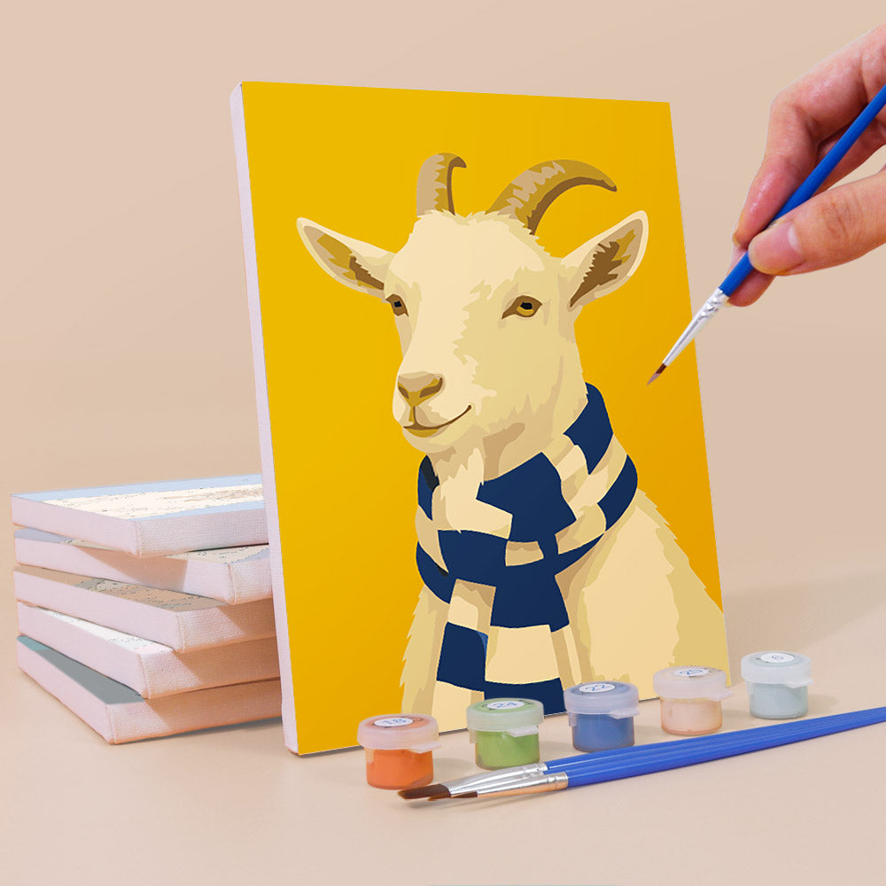 Painting a Style Critters mini canvas propped up beside numbered acrylic paints