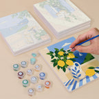 Painting one of the Summer Escapes designs next to a stack of mini canvases