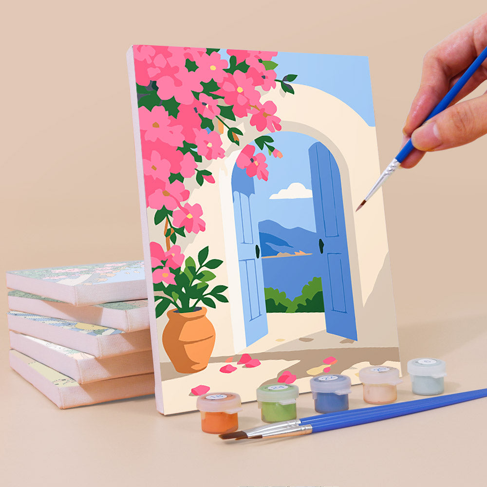 Painting a Summer Escapes mini canvas propped up beside numbered acrylic paints